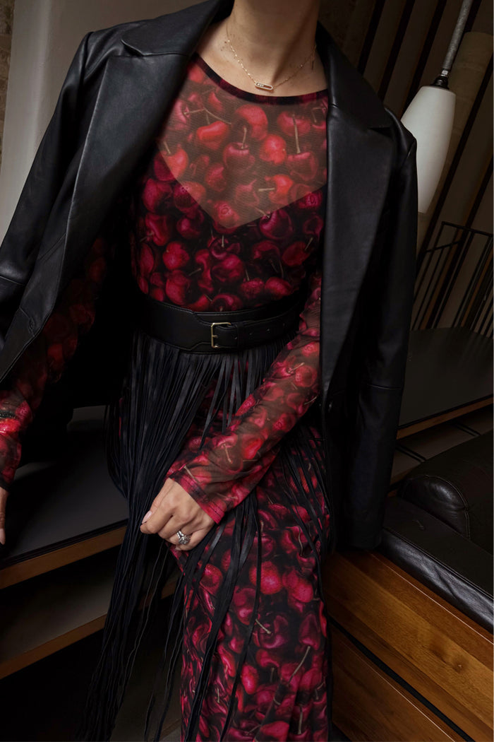 Black Leather Fringe Belt with long tassels and a wide band, layered over a cherry print mesh dress and jacket.
