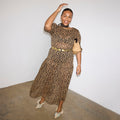 Iconic Leopard Lucia sheer dress with puff sleeves and a tiered skirt, styled with a gold belt.