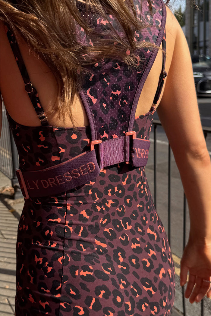 Leopard Running Bag in dark plum leopard print with branded straps, worn over a matching leopard print outfit.