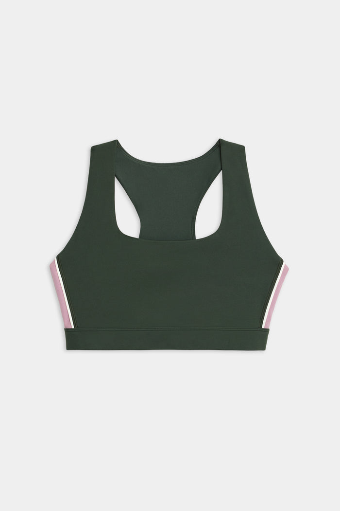 The SPLITS59 Lexi Rigor Bra, a dark green racerback sports bra featuring pink and white side stripes, is displayed on a white background.