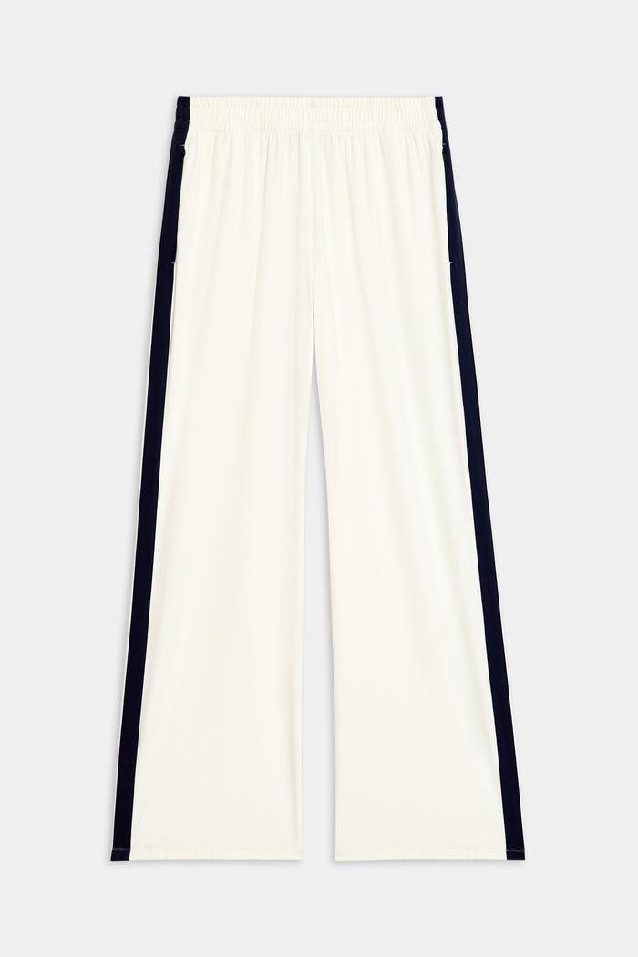 The Maxie Rigor Track Pant in white and indigo from SPLITS59, made from rigor fabric with an elastic waistband, is shown on a plain background.