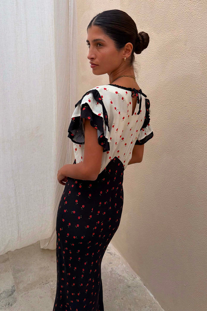 Mono Rose Betsy Midi Dress in a black and white rose print with frill sleeves and tie-neck detail.