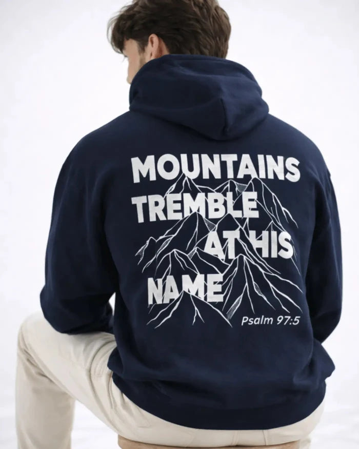 Person wearing a navy hoodie with mountain design and text on the back