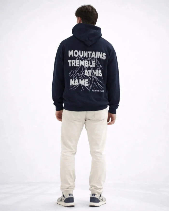 Person wearing a navy hoodie with text on the back, standing against a white background