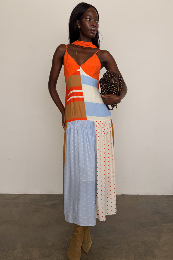 Multi Stripe Bea Dress in orange and blue with a pleated polka dot skirt and matching neck scarf on a model.