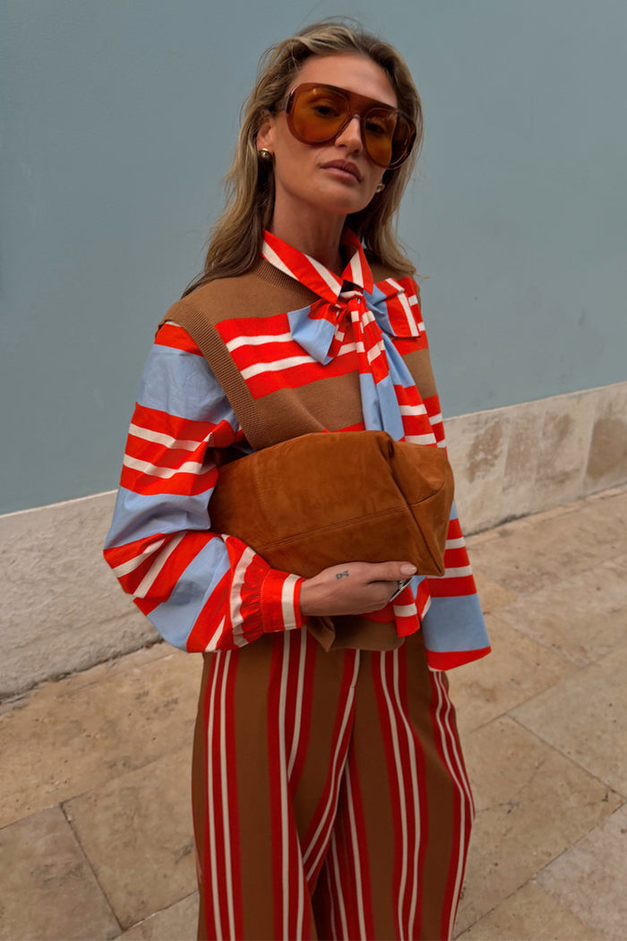 Multi Stripe Tank Top in tan and red knit, layered over a striped shirt with a bow and matching striped trousers.