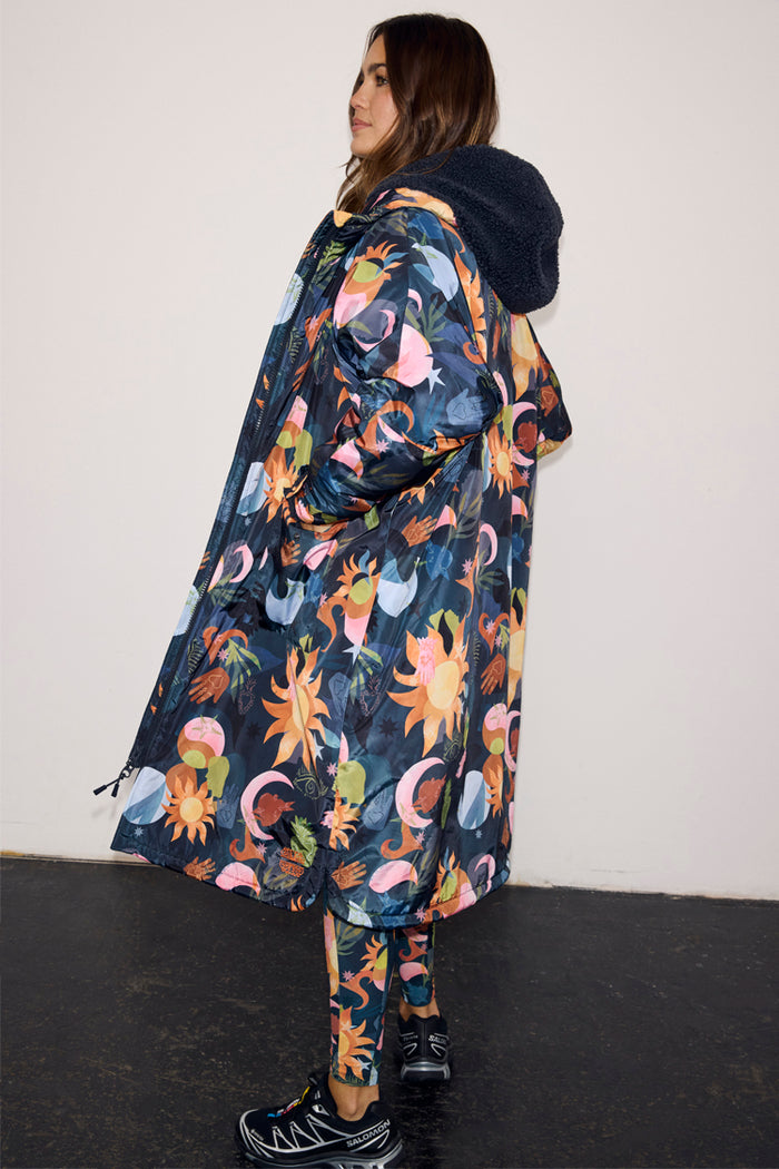 Navy Charm Coat with a hand-painted charm print and a navy borg-lined hood, styled with matching printed leggings.