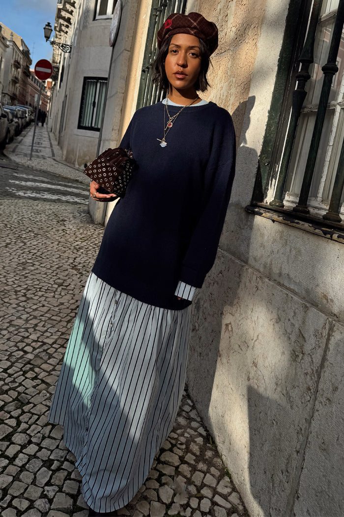Navy Knit Jumper Dress with a blue stripe cotton skirt, styled with a brown beret on a cobblestone street.