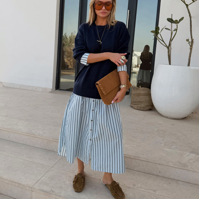 Navy Knit Jumper Dress with a blue striped cotton skirt and button front, styled with a brown suede clutch.