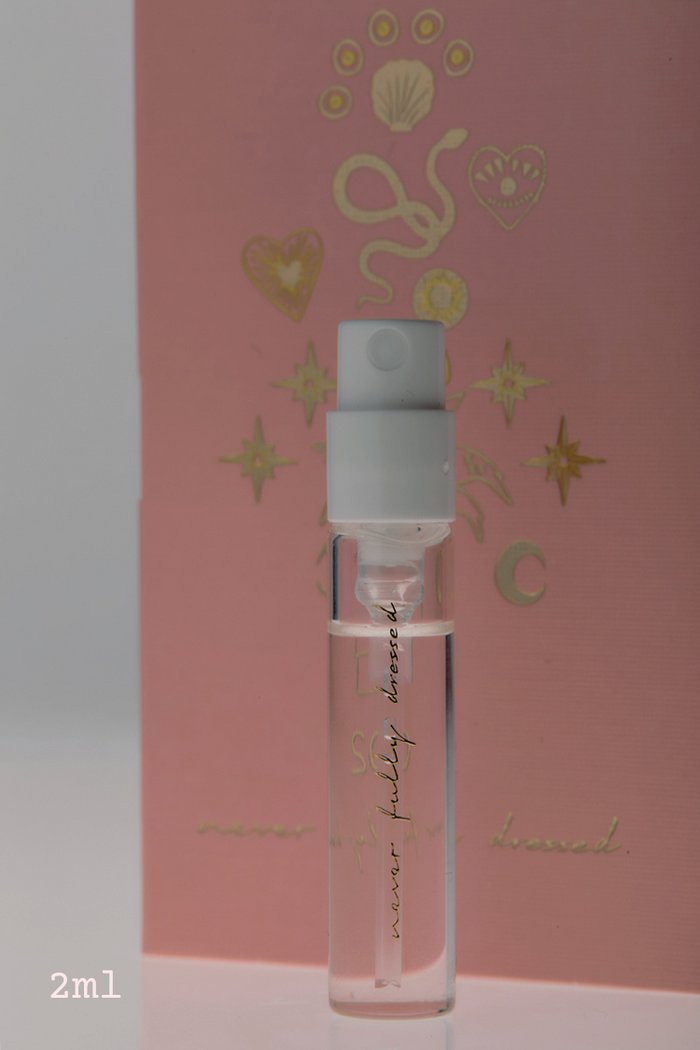NFD Eau De Parfum 002 2ml sample vial with gold script, displayed in front of a pink and gold celestial card.