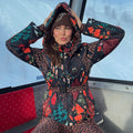 Night Garden Ski Jacket with leopard and poppy motifs, featuring a hood and waist belt inside a ski gondola.