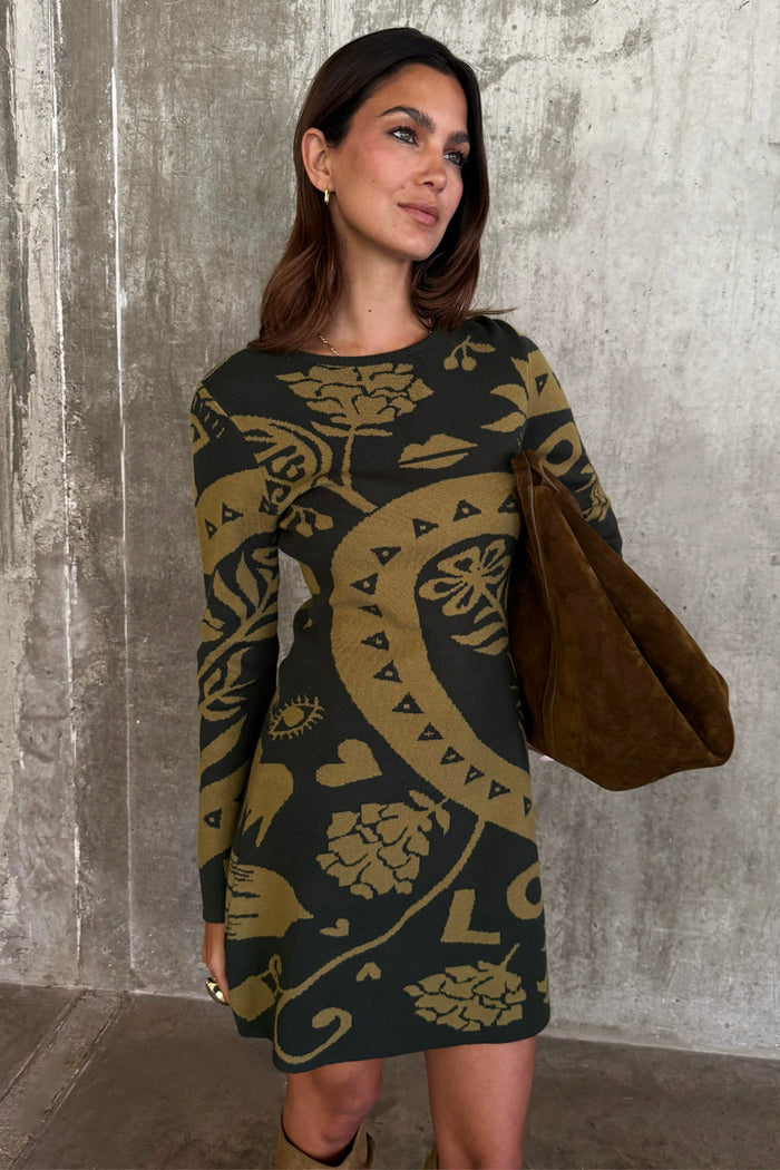 Olive Amara Knit Mini Dress featuring iconic motifs on a soft khaki knit base, paired with a suede bag.