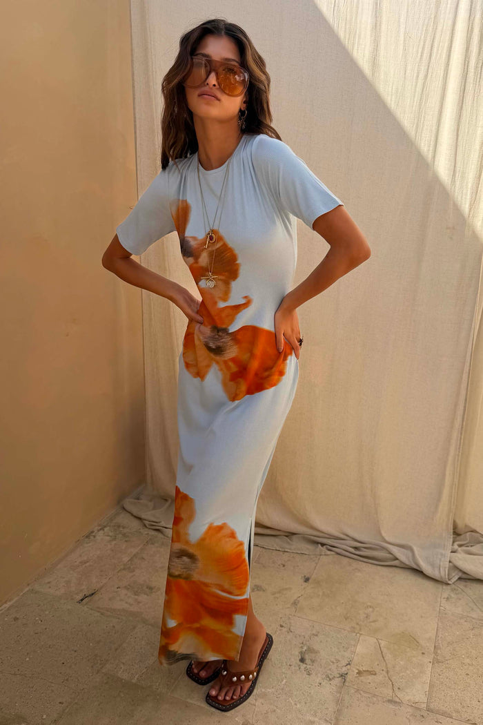 Orange Acetate Visor Sunglasses with tinted lenses worn with a light blue floral ribbed midi dress.