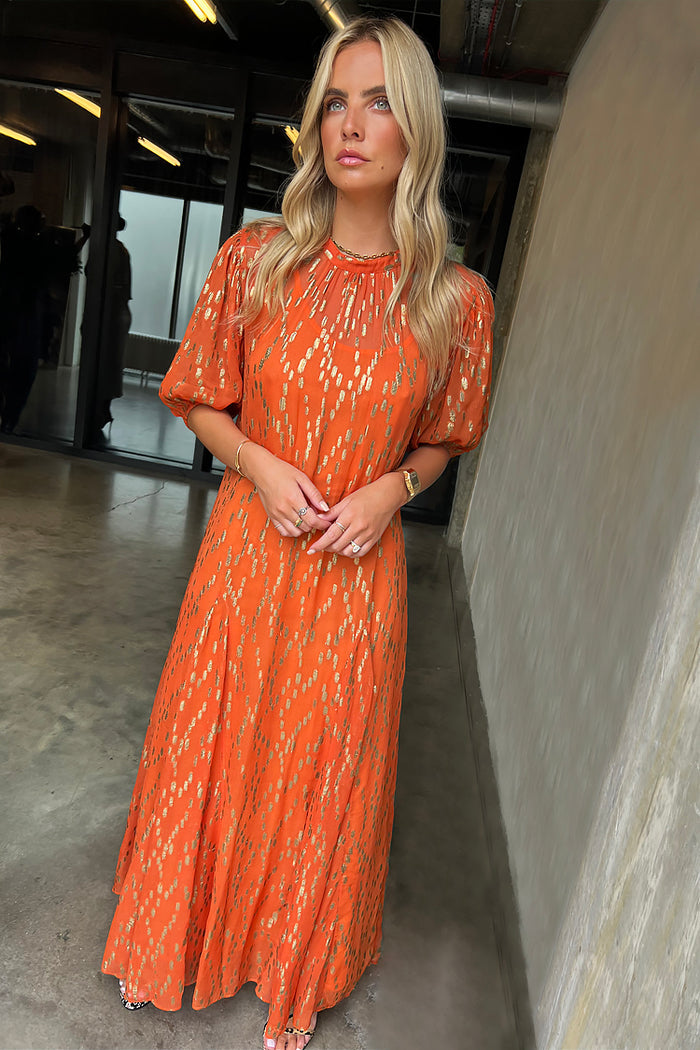 Orange Jacquard Bibi Dress featuring gold threads and puff sleeves in a smock silhouette on a model.