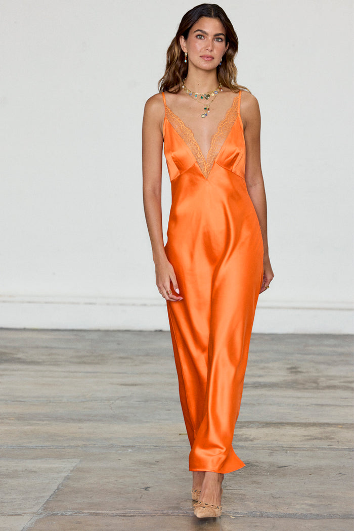 Orange Lily midaxi dress in silky satin featuring a lace V-neckline, shown on a model.
