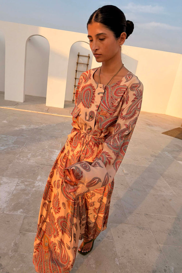 Peach Paisley Anna Top with a tie waist and long sleeves, styled with matching balloon trousers in an outdoor setting.