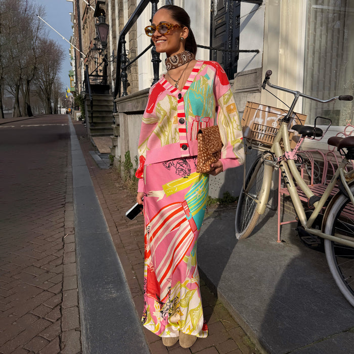 Pink Dallas Dorris Skirt featuring abstract cowgirl motifs, styled with a matching cardigan in a street setting.