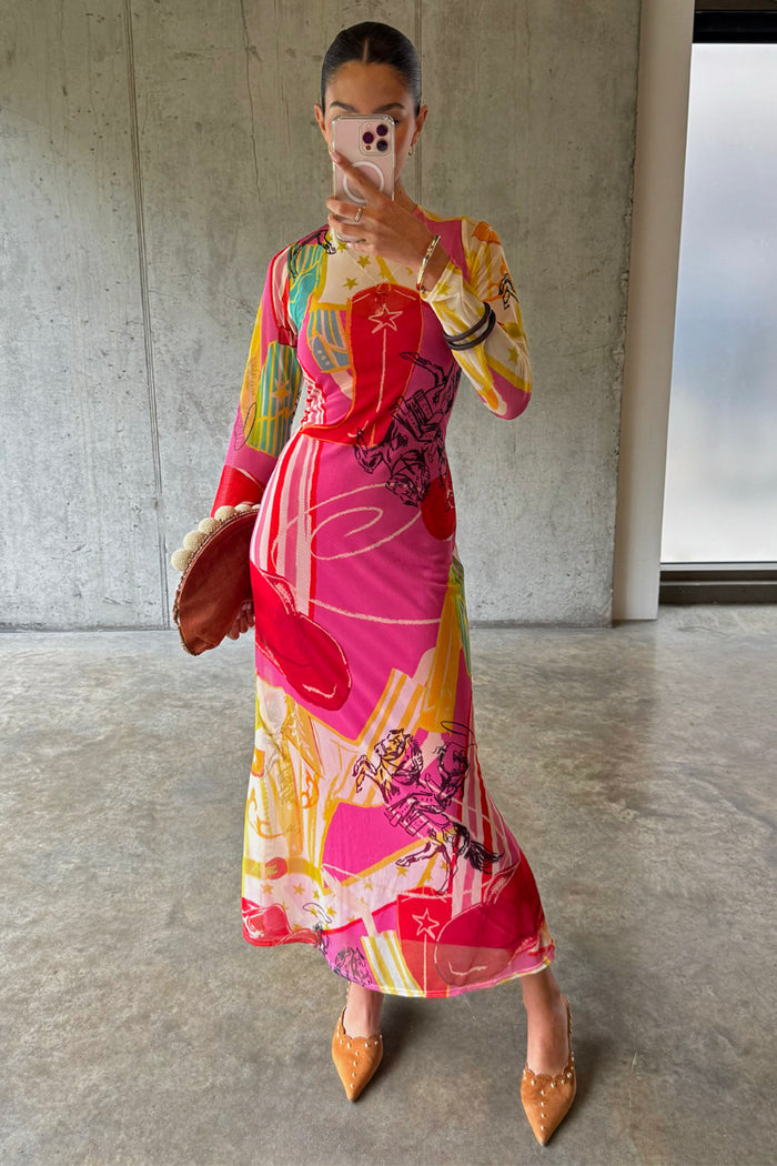 Pink Dallas Mesh Dress with abstract cowboy motifs, long sleeves and a midaxi length, shown in a mirror selfie.
