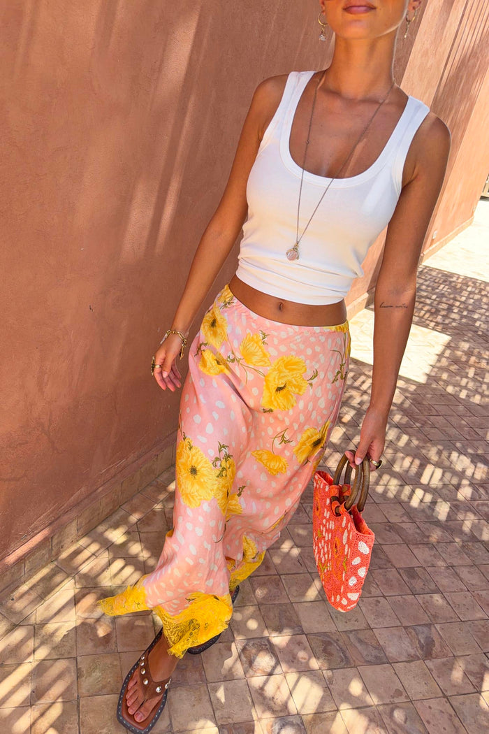 Pink Fawn Poppy Maeva Petite midi skirt with yellow poppy motifs and lace hem, styled for a vacation look.