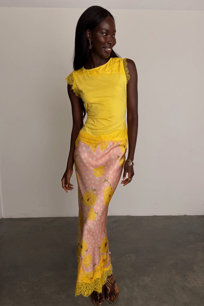 Pink Fawn Poppy Midi Maeva Skirt with yellow lace trim and deer motifs, designed in London and styled with a yellow top.