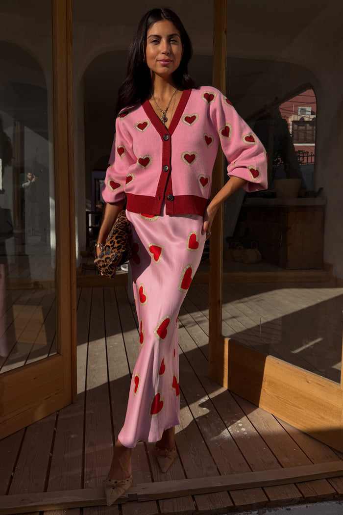 Pink Hearts Cardigan with red embroidered hearts and contrast trims, styled with a matching heart print skirt.