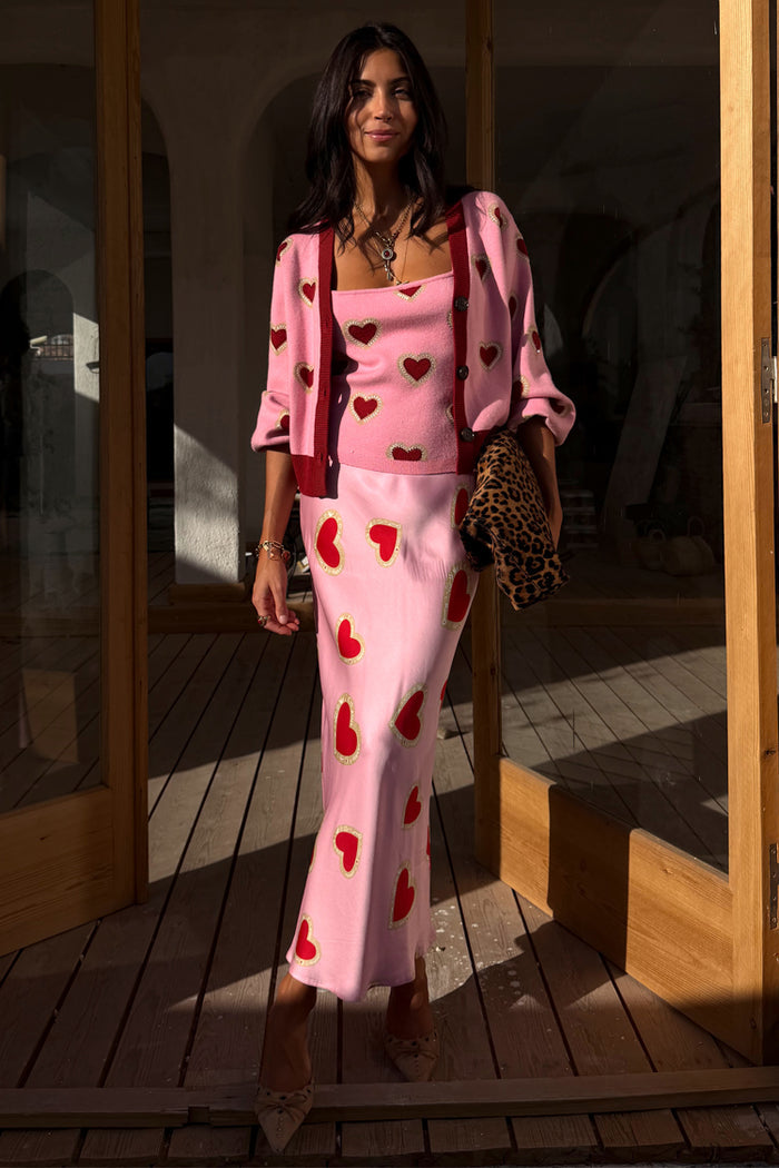 Pink Hearts Cardigan with red embroidery and contrast trims, layered over a matching tank and skirt with a leopard clutch.