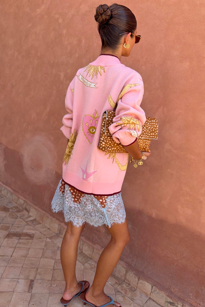 Pink Mystical Cardigan with sun and moon jacquard motifs and burgundy trims, shown from the back on a model.