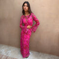Pink Paisley Mesh Dress featuring long flared sleeves and a bright paisley print, styled with gold jewellery.