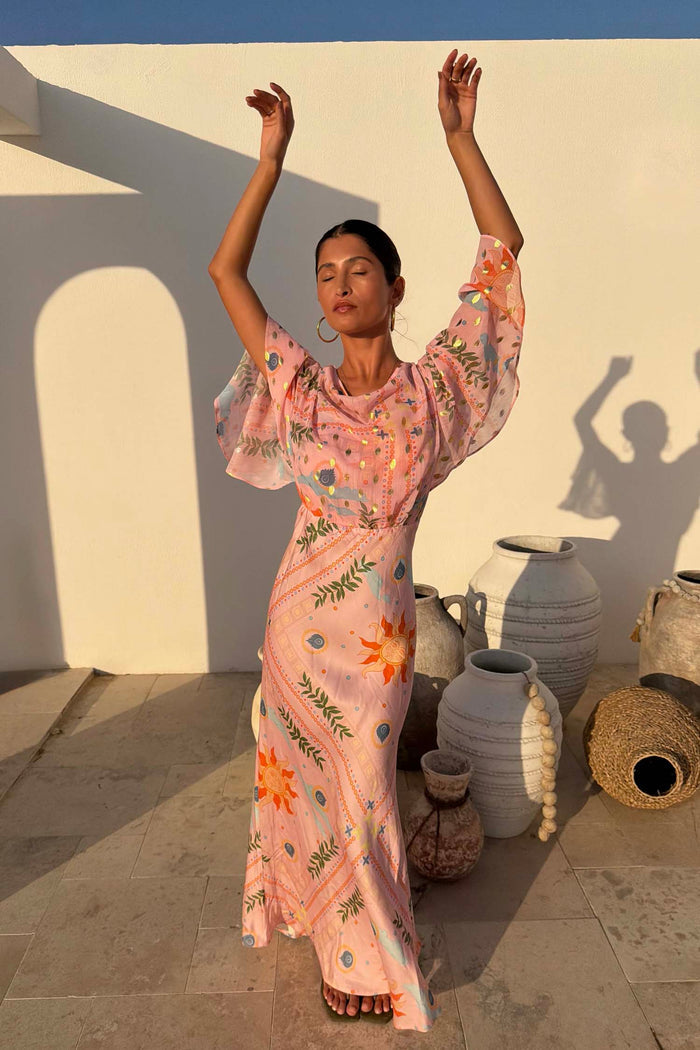 Pink Sun Anais Dress with soleil motifs, featuring a sheer draped top and satin-esque bias cut skirt.