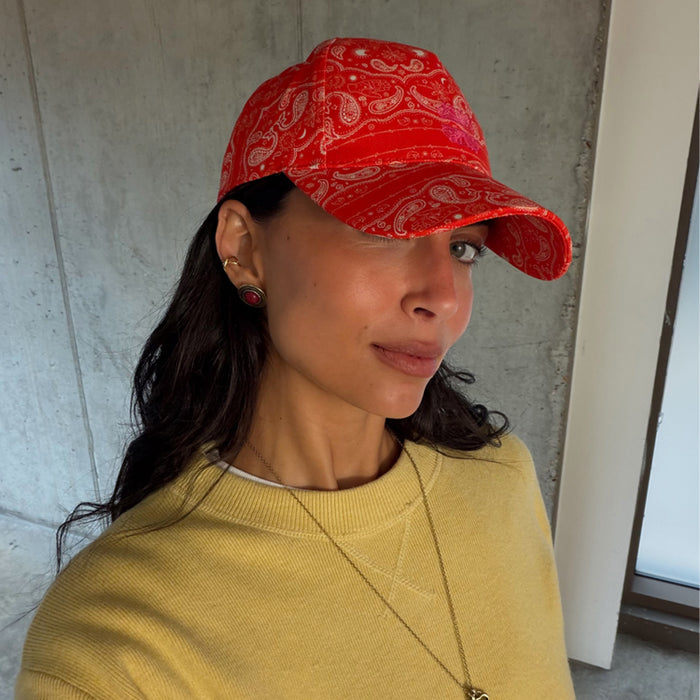 Red Bandana Cap in cotton with a pink embroidered NFD logo and white paisley print, worn with a yellow sweater.