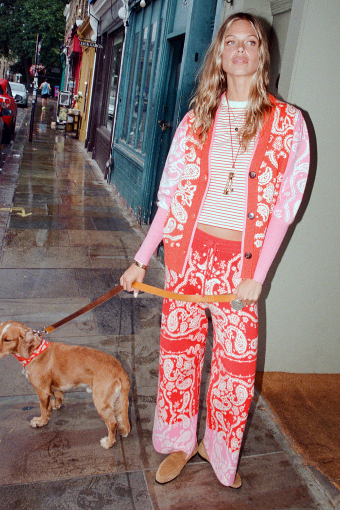 Red Bandana Martha Cardigan in a red and pink knit bandana print, styled as a co-ord on a London street.