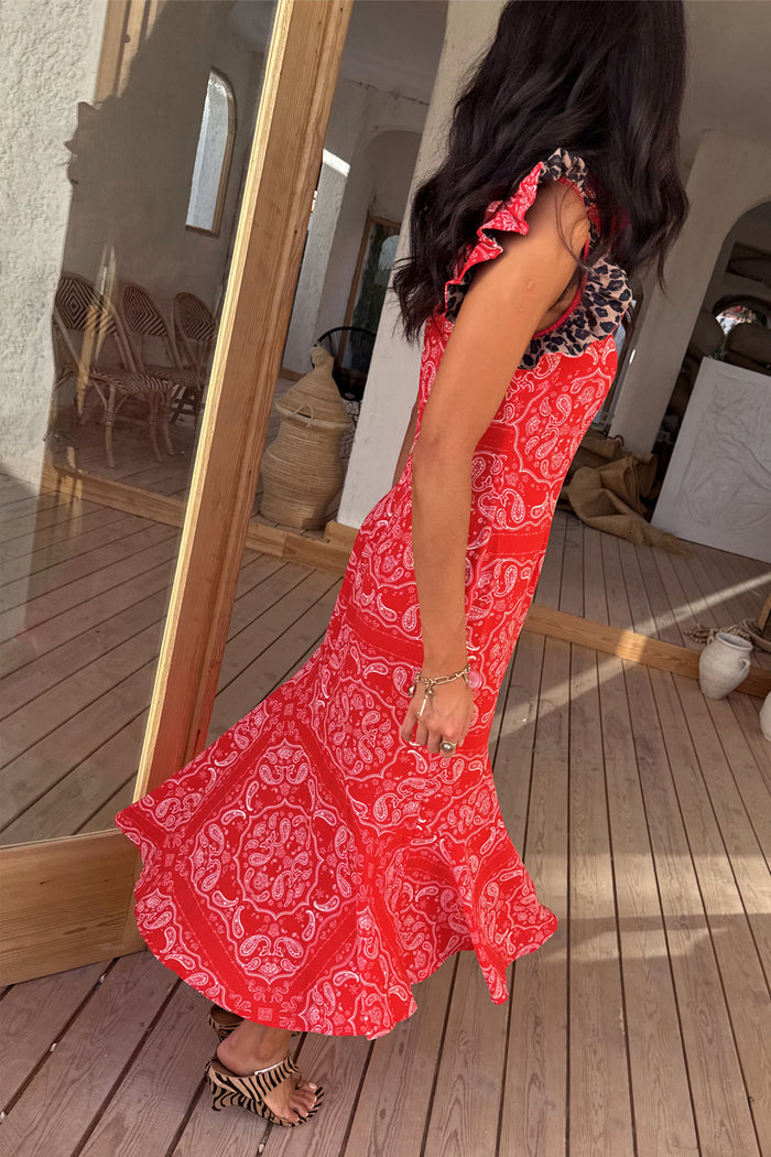 Red Bandana Remi Dress featuring leopard print frill sleeves and an asymmetrical hem on a sunlit wooden deck.