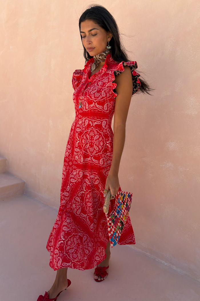 Red Bandana Remi Dress featuring a ruffled neck and leopard print sleeves, styled with a patterned clutch.