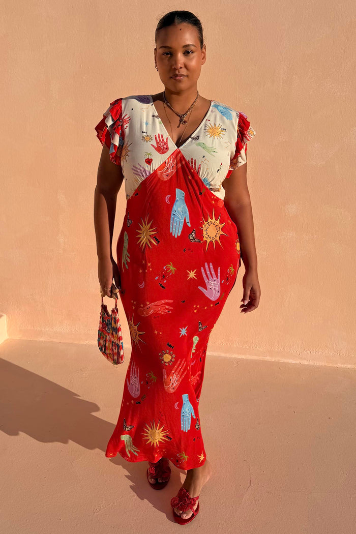 Red Celestial Midi Dress featuring a cream V-neck blouson top and celestial sun and hand motifs.