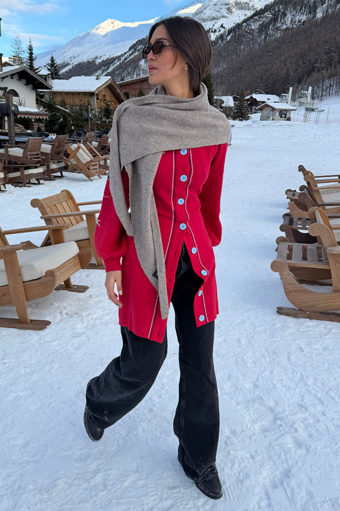 Red Ski Knit Long Cardigan with light blue buttons and embroidered motifs, styled in a snowy mountain setting.