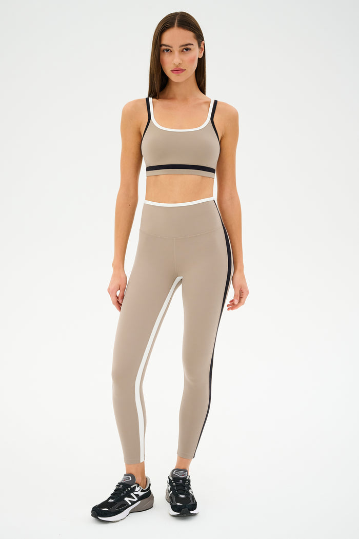 Dressed for gym workouts, the person is wearing a SPLITS59 Sam High Waist Rigor 7/8 set in Latte/Black and black sneakers.