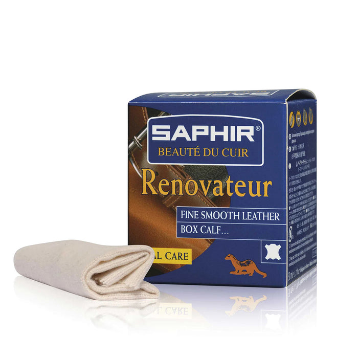 A box of Saphir Renovateur fine smooth leather cream with a 50ml jar and a cloth next to it.