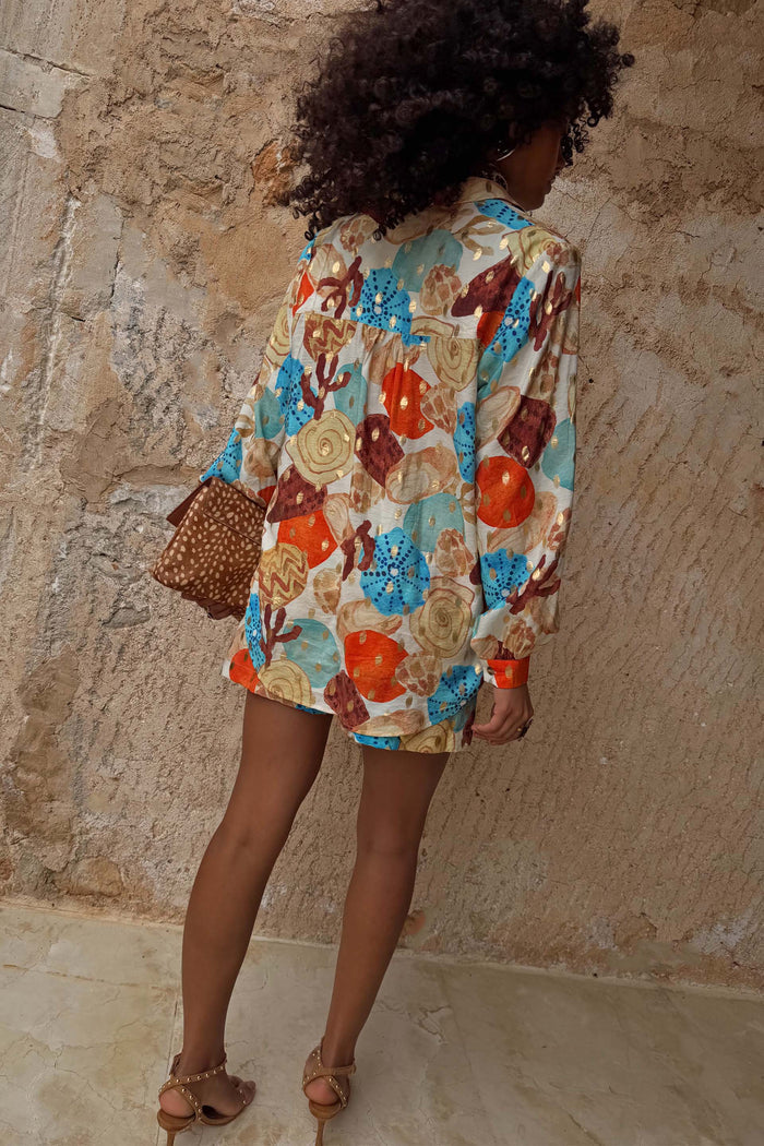 Shell Marley Shirt in a multi-coloured abstract shell print with metallic gold detailing, shown from the back.