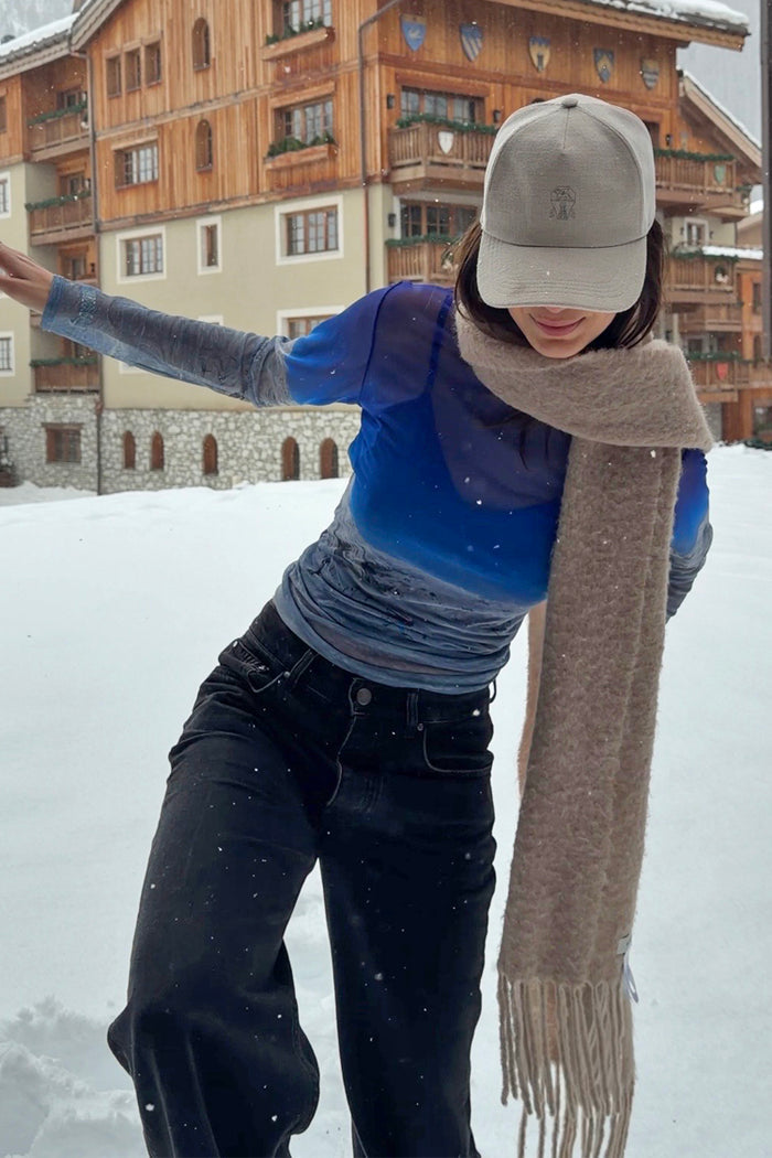 Blue gradient Ski Slopes Mesh Long Sleeve Top in sheer mesh, worn by a model outdoors in a snowy ski resort.