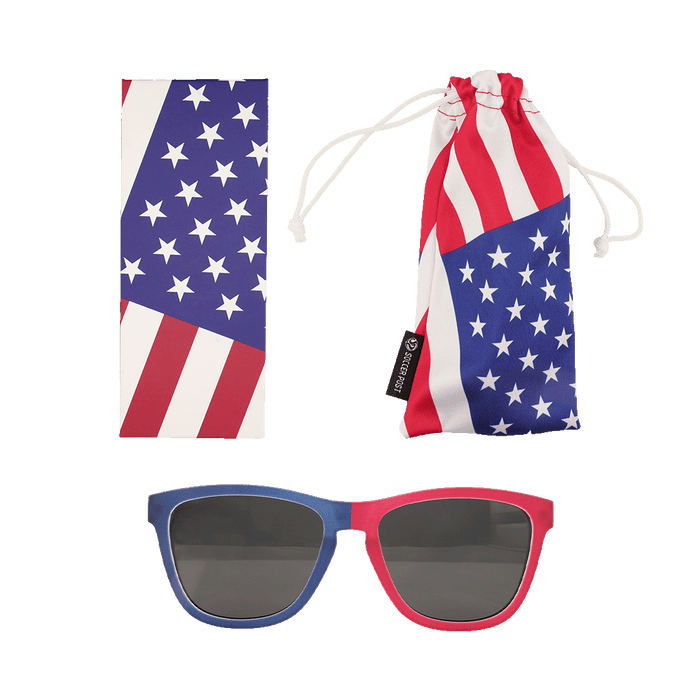 A set of American flag-themed accessories featuring patriotic red, white, and blue colors. The set includes a pair of sunglasses with one blue frame and one red frame, a rectangular cleaning cloth with a star and stripe pattern, and a matching soft drawstring pouch labeled with a "Soccer Post" tag.