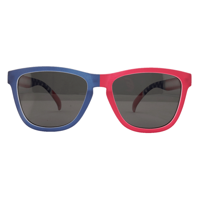 A pair of Wayfarer-style sunglasses with a split blue and red frame and dark lenses, shown against a white background.