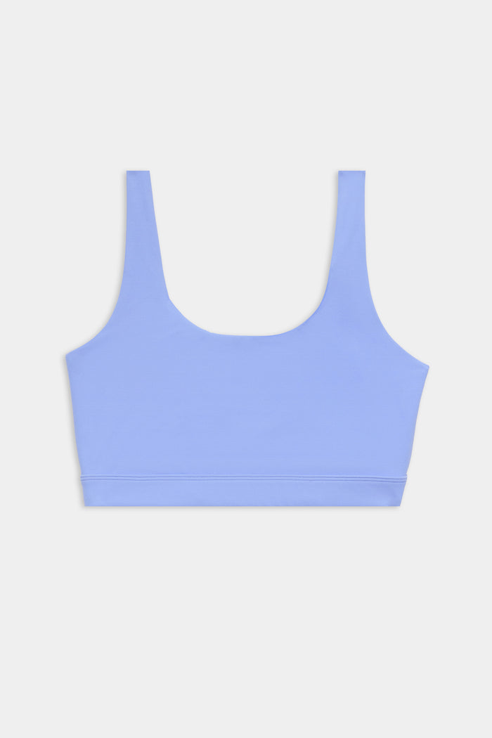 A light blue sports bra with wide shoulder straps and a scoop neckline, displayed on a plain white background.