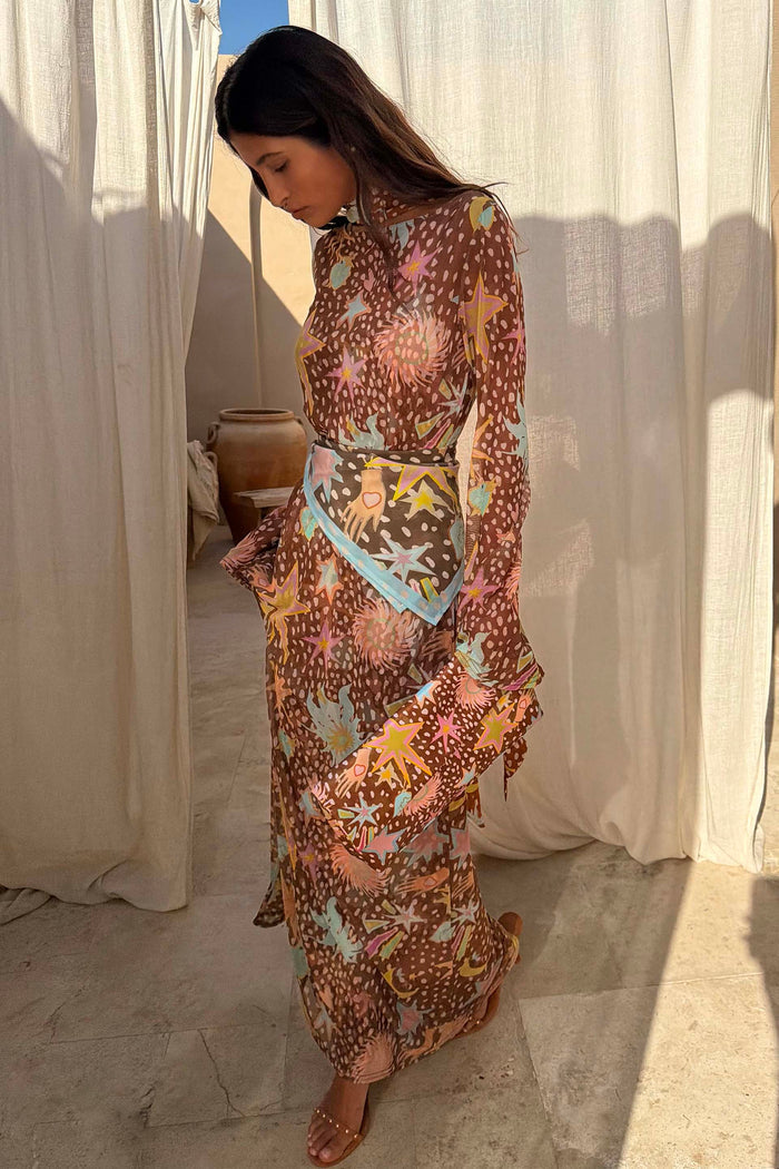 Star Fawn Aria Mesh Dress in brown with celestial motifs and flared sleeves in sheer mesh fabric, shown on a model.