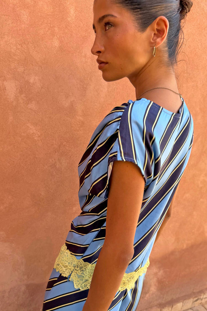 Stripe A-Symmetrical Top in blue and navy with yellow lace trim, shown in a side profile view.