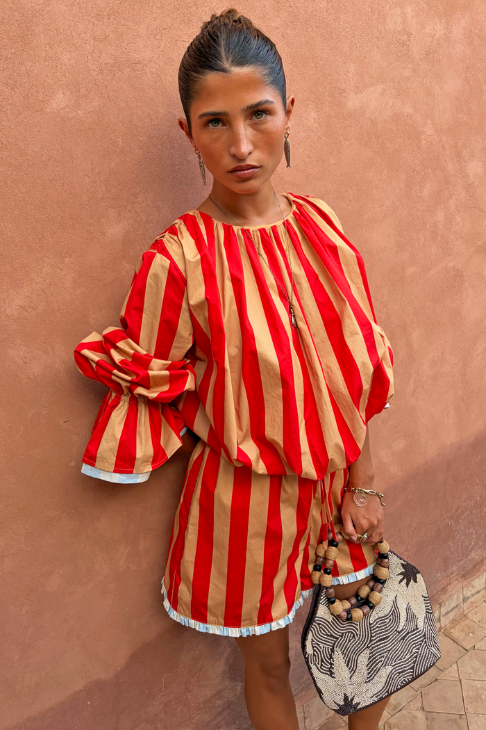 Red and camel Tomato Stripe Blouse with voluminous sleeves and drawstring waist on a model.