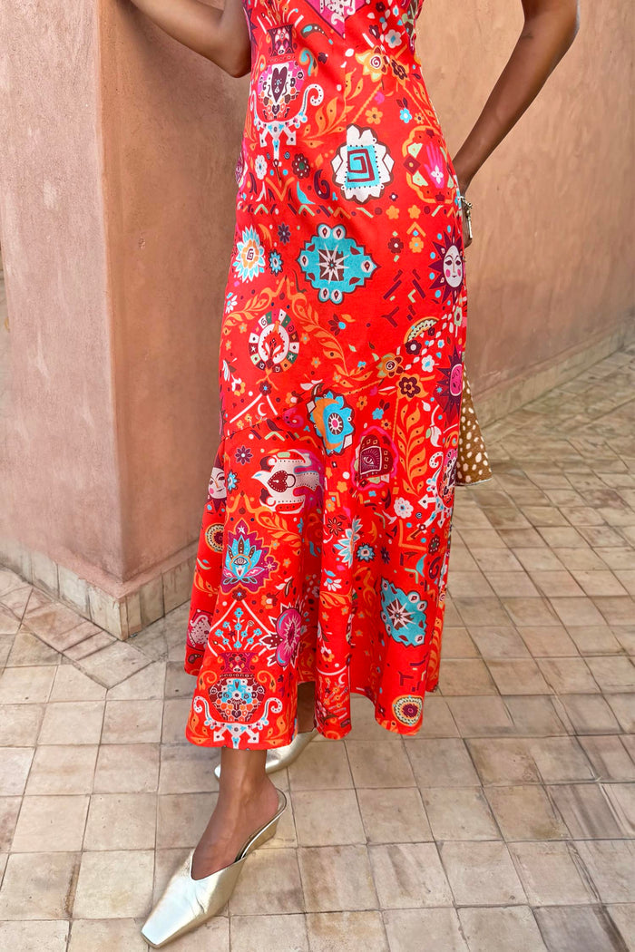 Red Tomato Tapestry Frida Dress featuring a sun motif patchwork print and fluted hem, styled with gold mules.