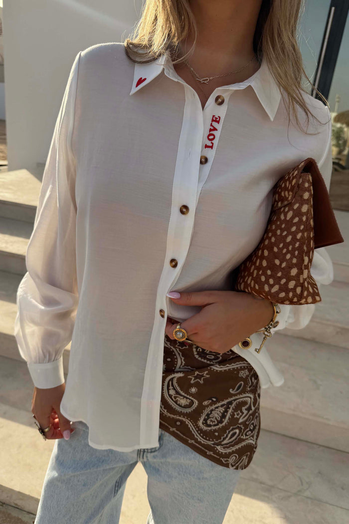 White Love Miley Shirt with red embroidery, tortoise buttons and blouson sleeves on a model.
