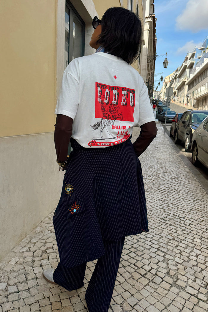 White cotton Rodeo T-Shirt with a red back graphic, styled with pinstripe trousers for a London look.