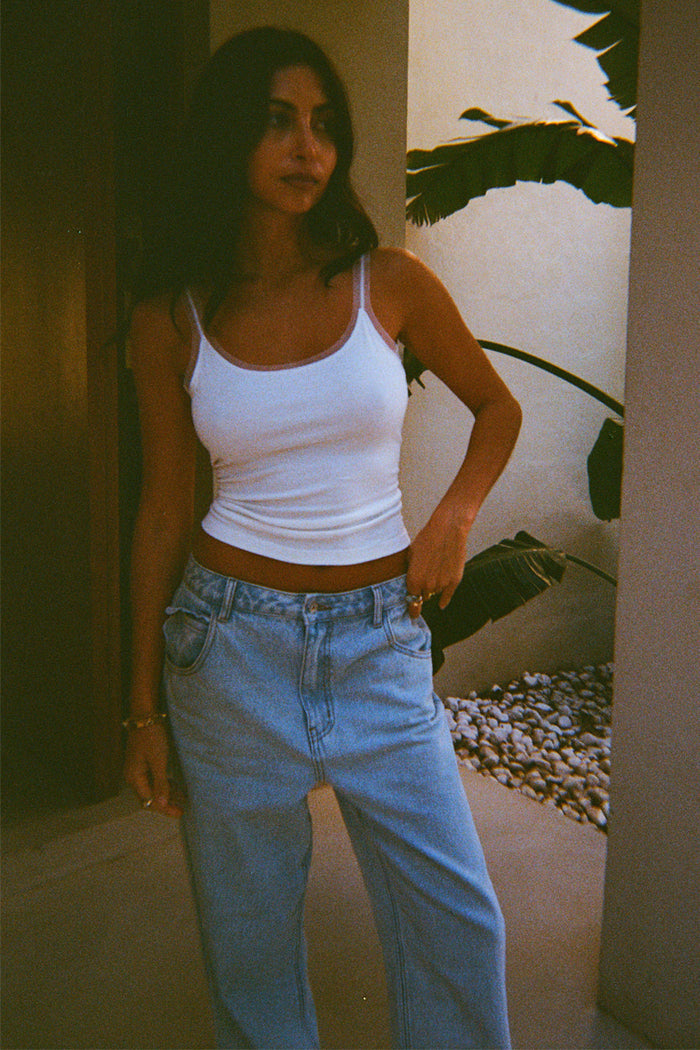 White Teddy Vest featuring mesh trim detailing, styled with light-wash blue denim jeans.