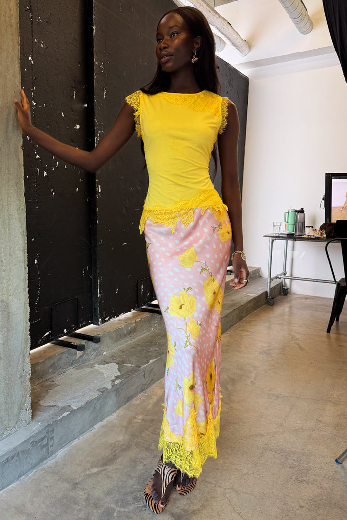 Yellow Lace Insert Top with an asymmetric lace hem and trim, styled with a pink floral skirt.